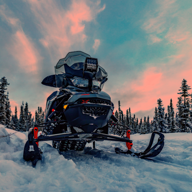 Snowmobile on a snow trail with sunset